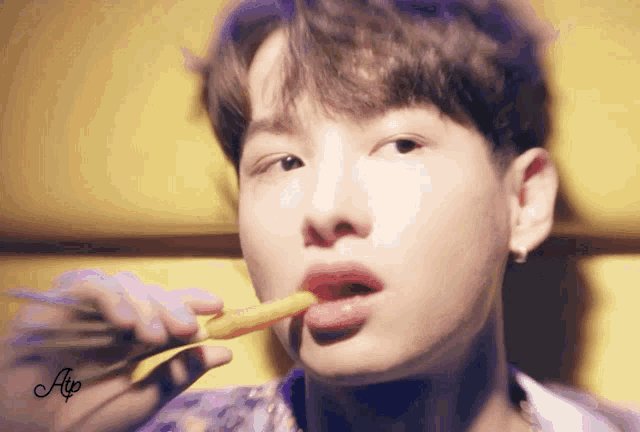 a close up of a person eating a carrot with the letter a on the bottom