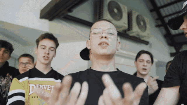 a man in a denver shirt is surrounded by other people