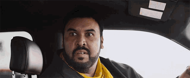a man with a beard is sitting in a car with a netflix logo on the bottom