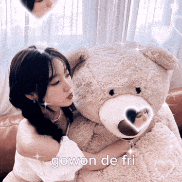 a woman is hugging a large teddy bear that says gowon de fri on it