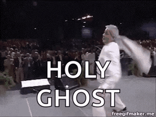 a man in a white suit is dancing on a stage with the words `` holy ghost '' .