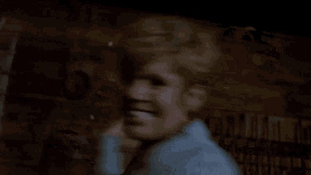 a woman is laying on her back with her arms outstretched and smiling in a dark room .
