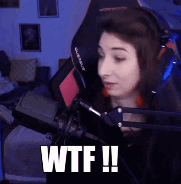 a woman is sitting in front of a microphone with the words wtf written on it