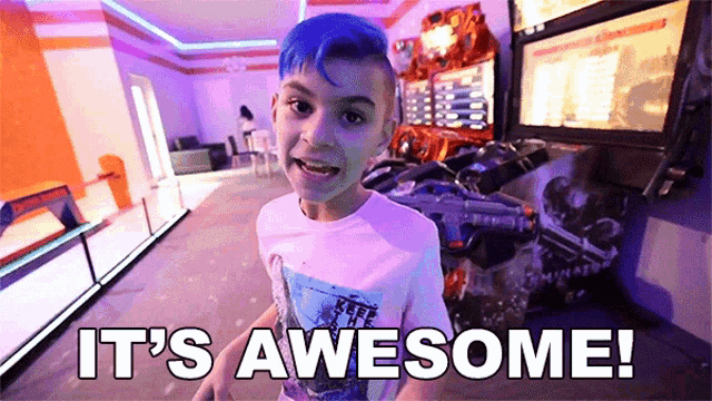 a boy with blue hair says it 's awesome in front of an arcade machine
