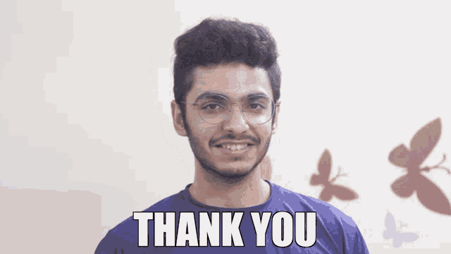a man wearing glasses and a blue shirt with the words thank you on it