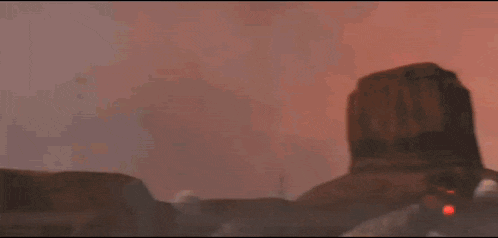 a person is holding a red laser beam in their hand in a dark room .