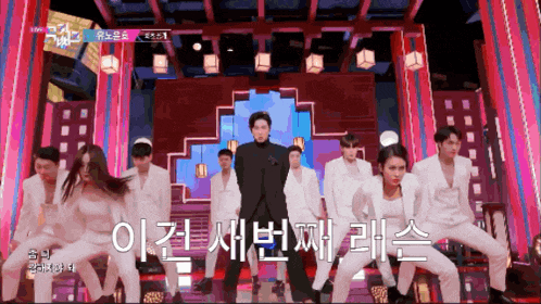 a group of people are dancing on a stage in front of a sign that says ' sbs '