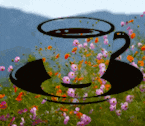 a cup of coffee on a saucer in front of a field of flowers