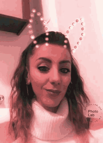 a woman is wearing a heart shaped headband with pearls