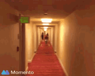 a blurry picture of a person walking down a hallway with the words momento on the bottom right