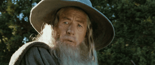 a man with a beard wearing a hat is looking up