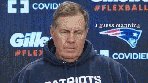 a man wearing a patriots sweatshirt stands in front of a gillette advertisement