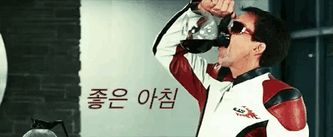 a man in a red and white jacket drinking from a bottle
