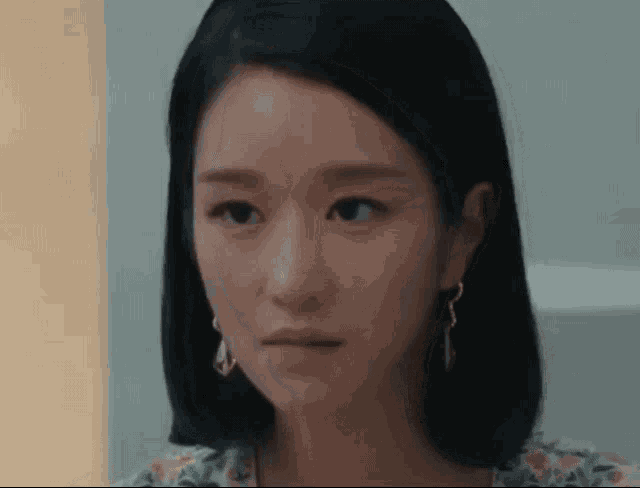 a close up of a woman 's face wearing earrings .