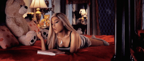 a woman is laying on a bed reading a book