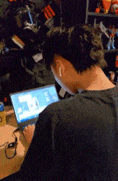 a man wearing ear buds is typing on a laptop