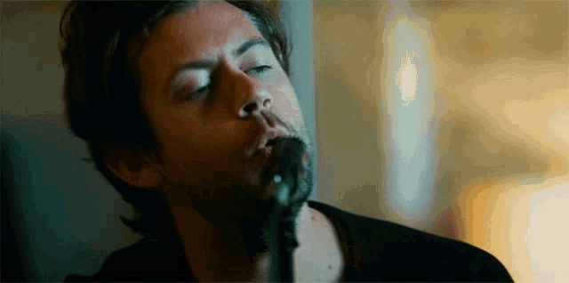 a man with a beard is singing into a microphone