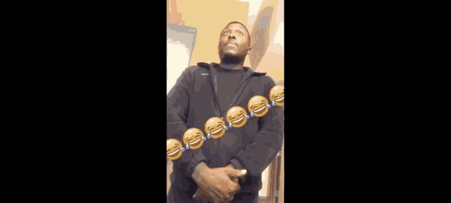 a man in a black jacket is standing in front of a door with a bunch of smiley faces on it .