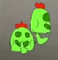 a couple of green cactus with a red top on a gray background .
