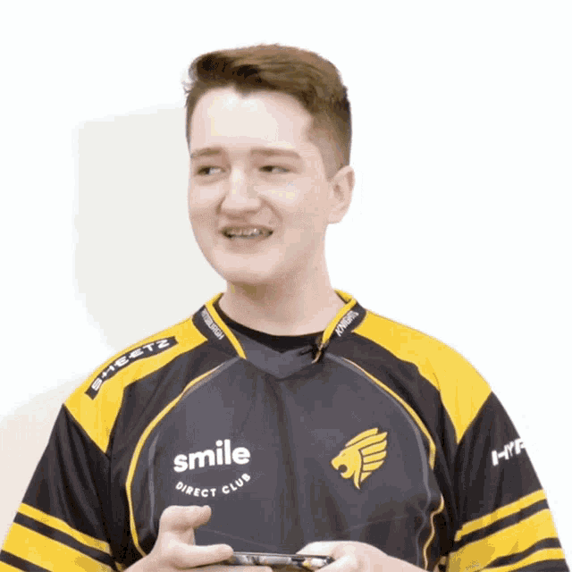 a man wearing a yellow and black shirt that says smile direct club