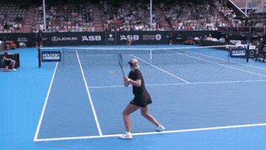 a woman is playing tennis on a court with sponsors such as lexus asb and manuka doctor