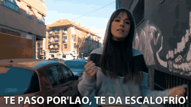 a woman stands in front of a car and says te paso por lao