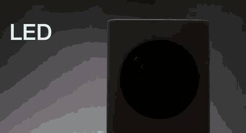 a white speaker is sitting in the dark with the word led in the background .