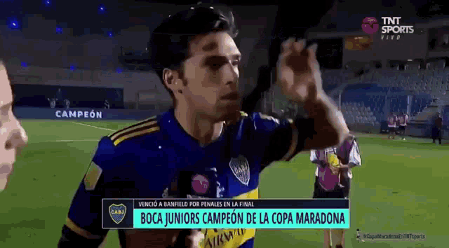 a man in a boca juniors jersey is giving a high five to another man