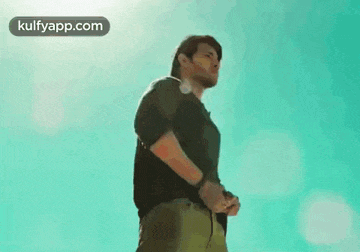 a man is standing in front of a blue sky holding a rope .