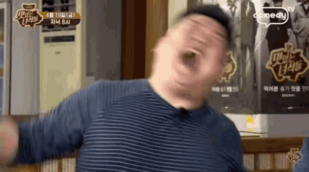 a man making a funny face in front of a comedy tv poster