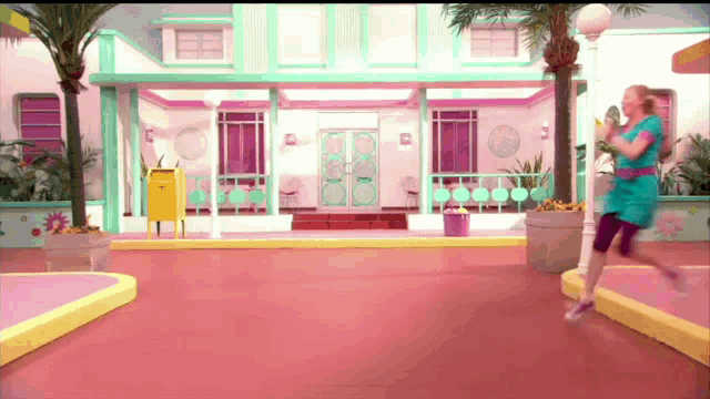 a woman in a blue dress is running in front of a pink building with a yellow mailbox