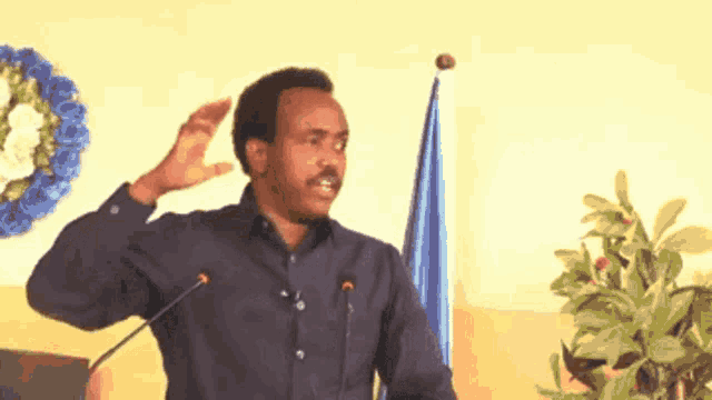 a man is giving a speech in front of a microphone