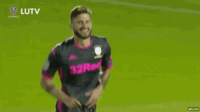 a soccer player wearing a 32red jersey celebrates a goal