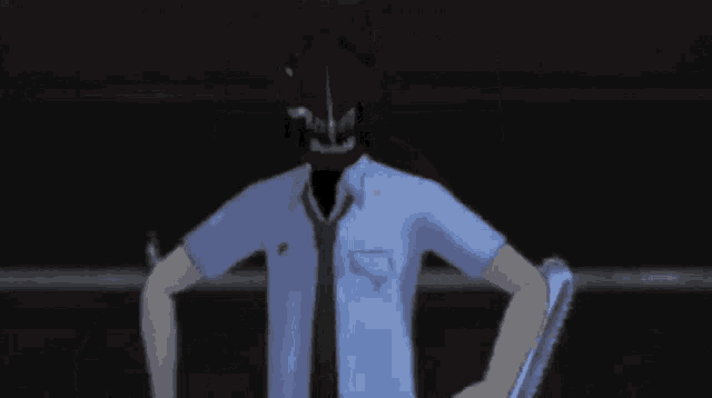 a man in a blue shirt and tie with a red mask on his head
