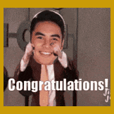 a man in a suit and tie is holding a cat on his shoulders and says congratulations