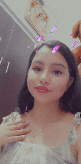 a girl with purple butterflies on her face takes a selfie