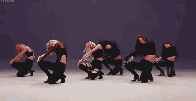 a group of women are dancing together on a stage in a row .