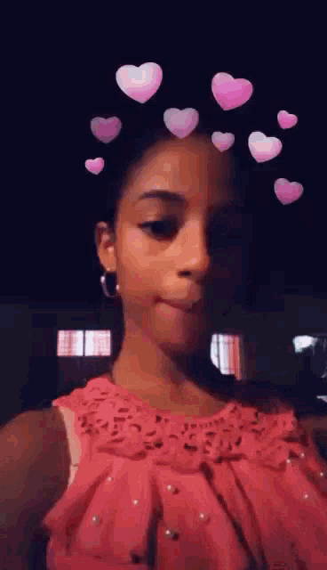 a young girl in a pink dress with pink hearts on her head