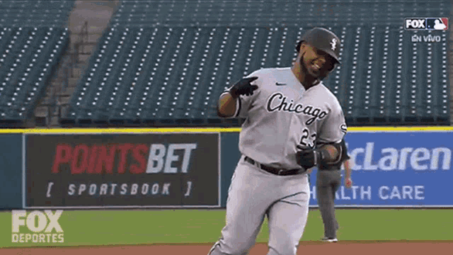 a baseball player wearing a chicago uniform is running on the field