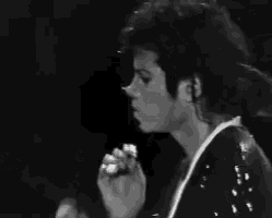 a black and white photo of a man in a sequined jacket dancing