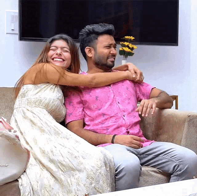 a woman is hugging a man on a couch