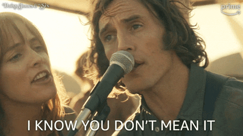 a man singing into a microphone with the words i know you don 't mean it