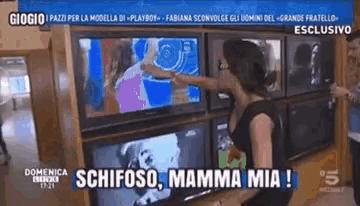 a woman is pointing at a television screen with the words schifoso mamma mia