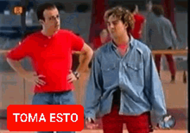 two men are standing next to each other and a red button says toma esto