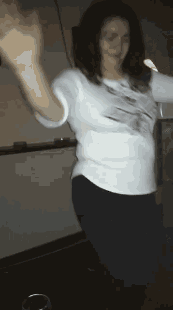 a woman in a white shirt and blue jeans is dancing