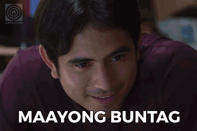 a man in a purple shirt is smiling and says maayong buntag