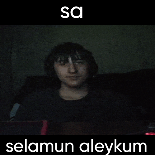 a man wearing headphones is sitting in a dark room with the words " sa selamun aleykum " on the bottom