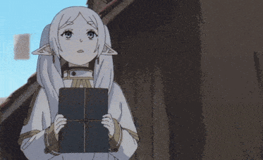 a girl with white hair and ears is holding a book in her hands