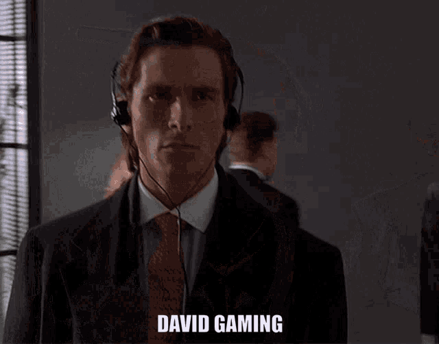 a man in a suit and tie is wearing headphones and the word david gaming is on the screen