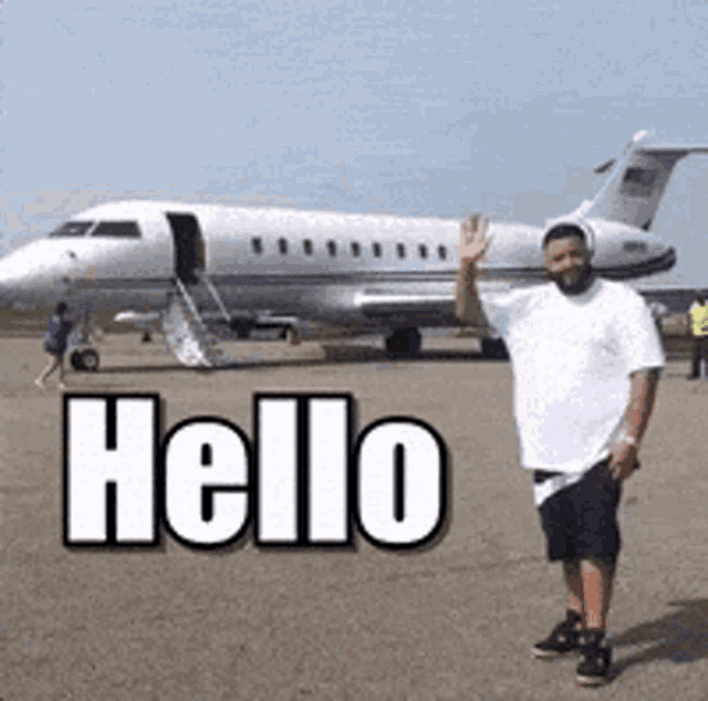 a man is standing in front of a plane that says hello on the ground